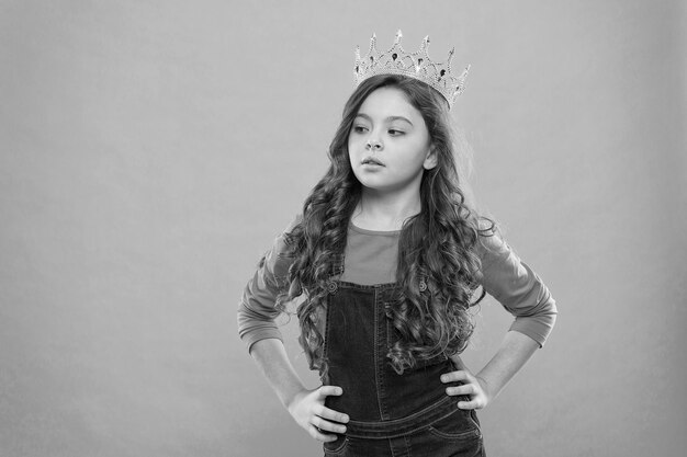 Small girl in queen crown feel herself like big boss being an egoist reward for real champion little princess selfish kid long curly hair luxury and success find your motivation copy space