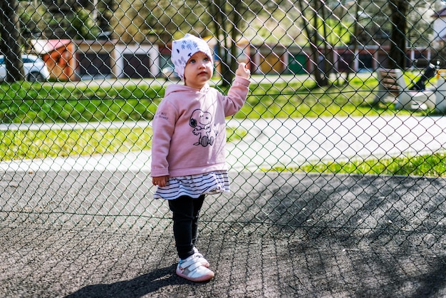 Small girl toddler holding fence