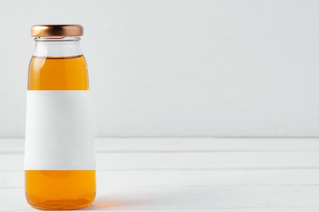 Photo small glass bottle of fresh juice on white background