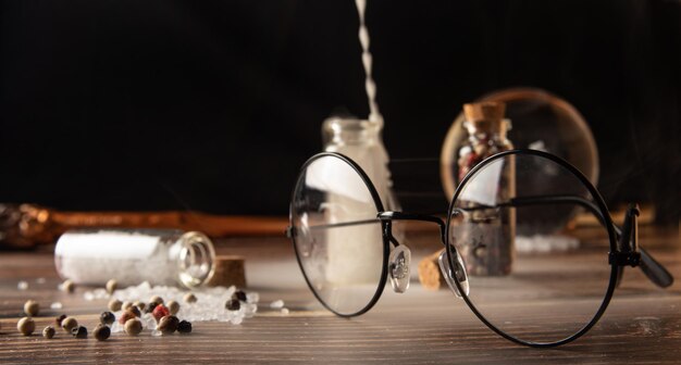 Small glasses with cork stopper with spices and empty smoke and more accessories black background selective focus