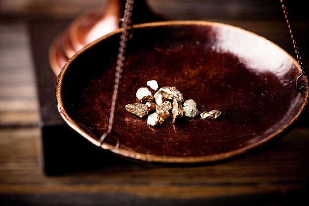 Small gold nuggets in an antique measuring scale