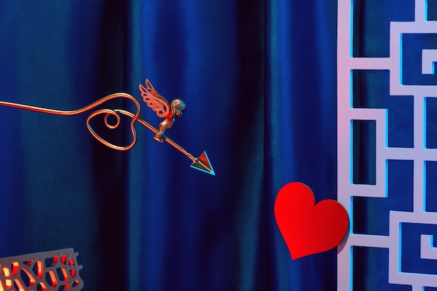 Small golden cupid marks his target with an arrow at the heart, valentine's day concept.