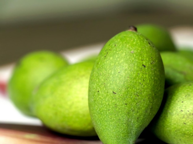 Small green mangoes on a wooden table