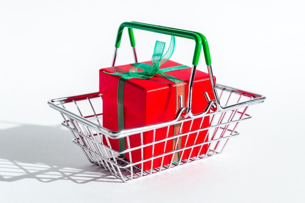 Small grocery basket with red gift box on white