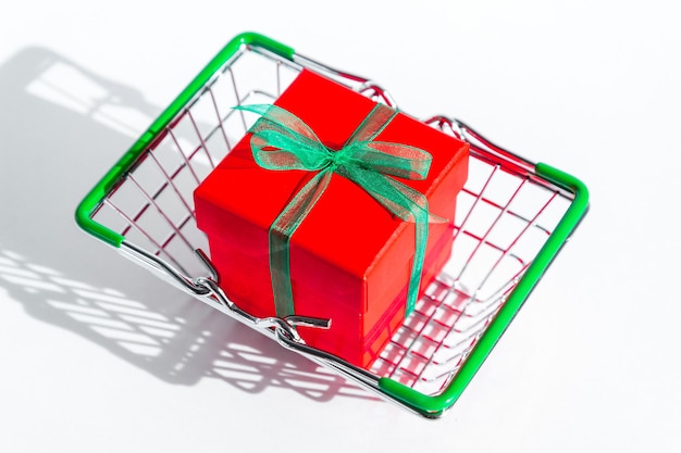 Small grocery basket with red gift box on white