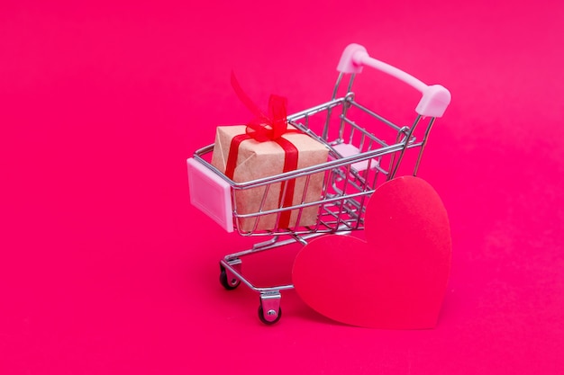 Small grocery cart with gift boxes. Give gifts with love on Valentine's Day