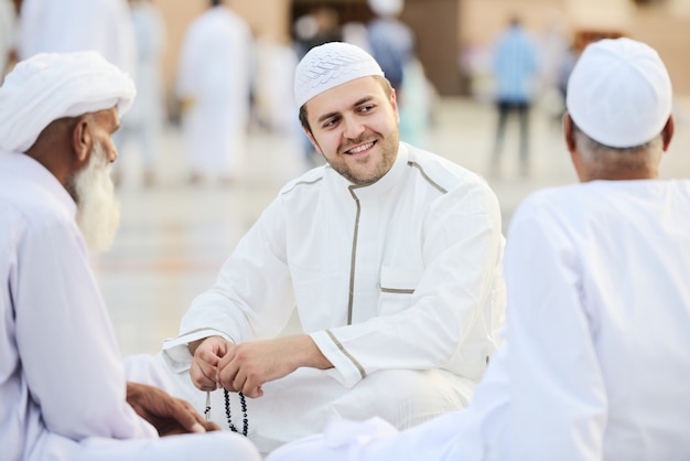 Small group of middle eastern friends sitting and talking outdoors