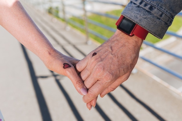 Foto piccoli cuori. stretta di mano con piccoli tatuaggi a forma di cuore tenuti insieme