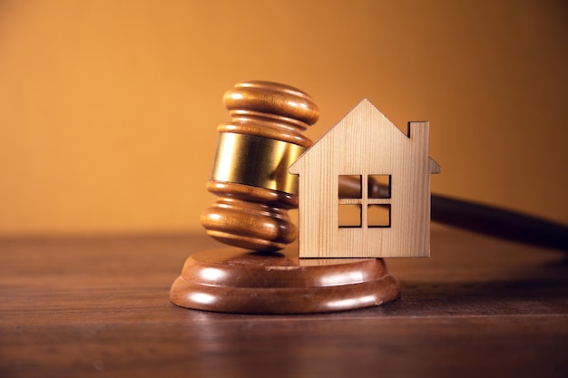 A small house and a judge's gavel on the table