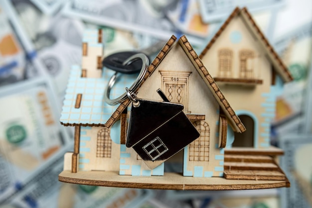 Small house model with keys on 100 new US dollars banknotes