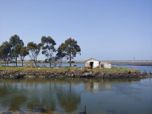 Photo a small house sits on the shore of a lake