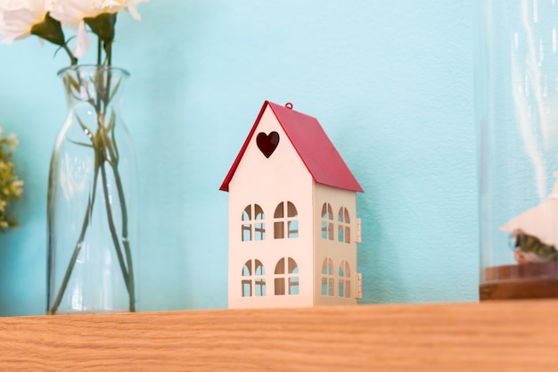 Photo small house toy with heart shape on wooden shelf decoration