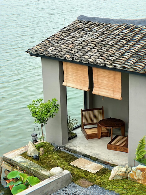 A small house with a roof that has a roof that has a wooden frame and a wooden chair on it.