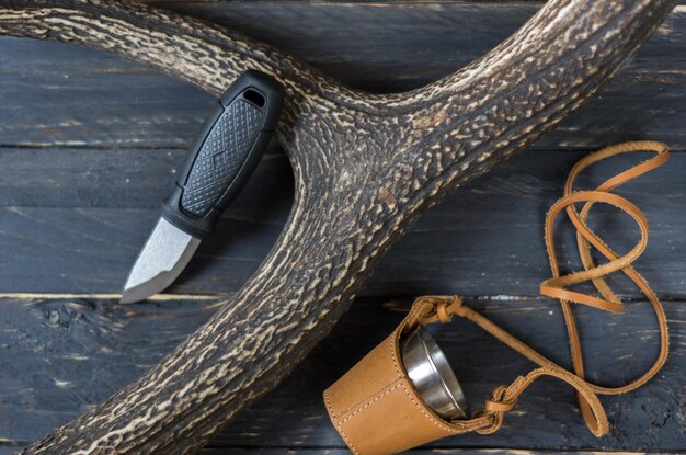 Small hunting knife and a glass in a leather case The horn of a deer Hunting