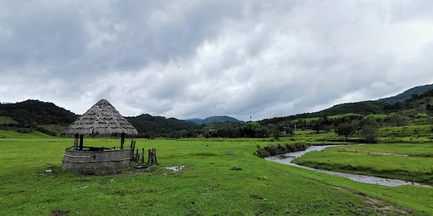A small hut in a field with mountains in the background