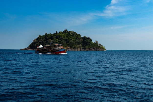 Foto piccola isola con barca da pesca sul mare in thailandia