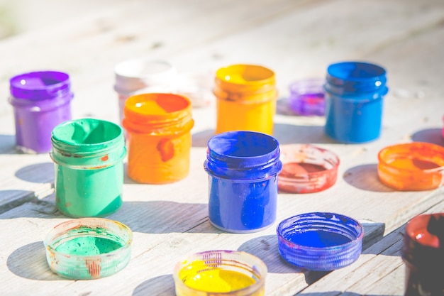 Small jars of paint gouache on a wooden table