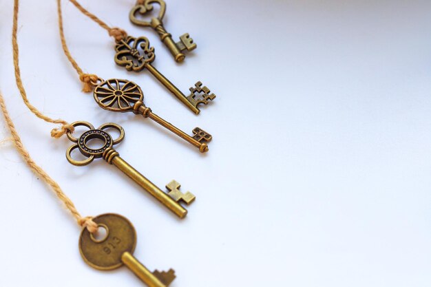 Small keys tied to ropes on white background