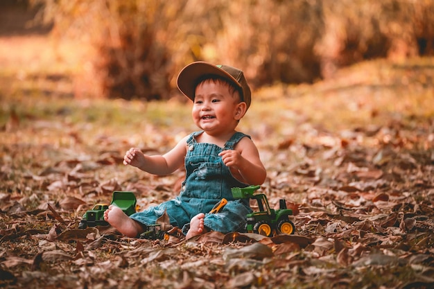 Фото Маленький ребенок сидит на земле в парке.