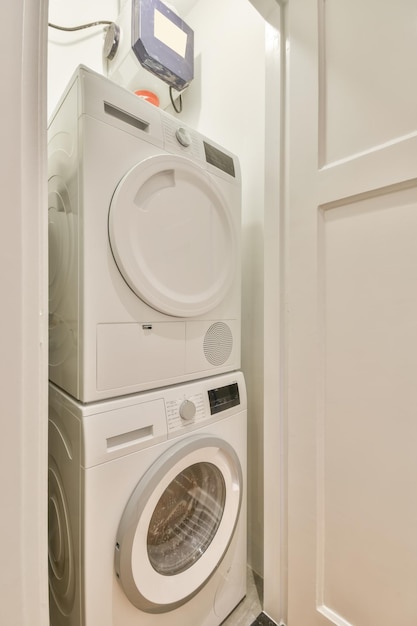 A small laundry corner with a washing machine and dryer in
white tones in a modern house