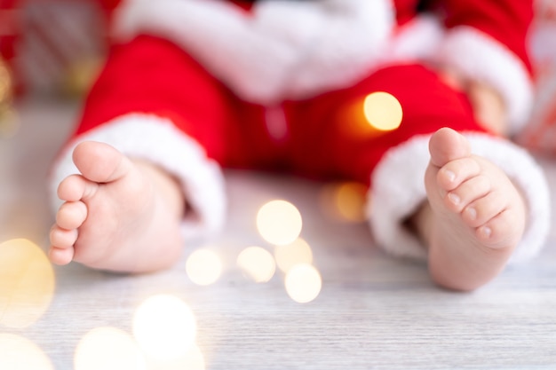 サンタ衣装のクローズアップ、新年、クリスマスの子供の小さな足