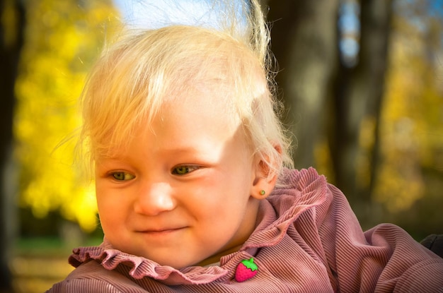 가을 공원에서 웃고 있는 작고 사랑스러운 아기