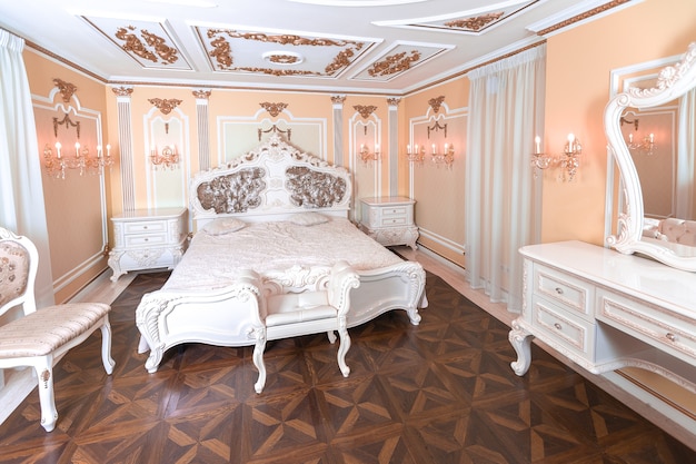 Small luxury bedroom with bath and expensive furniture in a chic old baroque style.