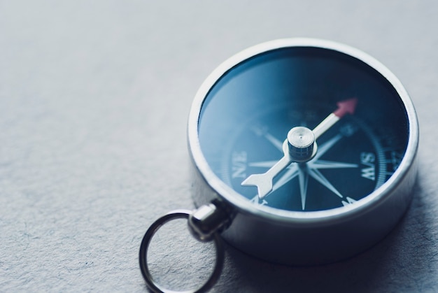 Photo small magnetic compass on a grey background