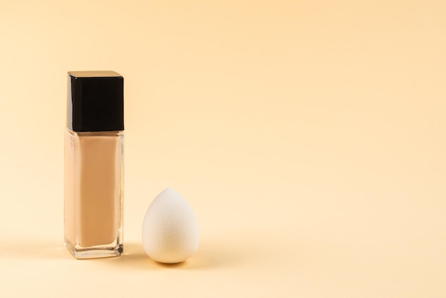 Photo small medium and large white beauty blender and makeup foundation on beige background top view