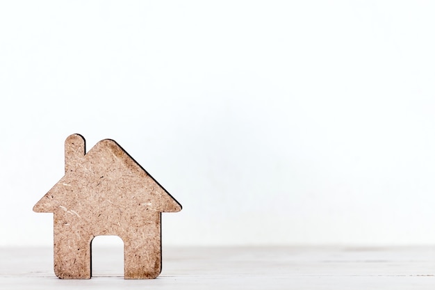 Small model house on wooden background