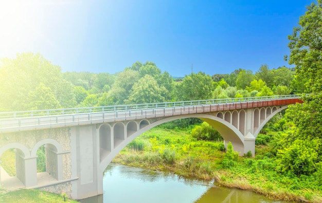 Small modern bridge across the river in soft sunlight