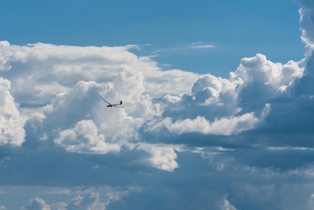 巨大な雲の前にある小さなモーター飛行機