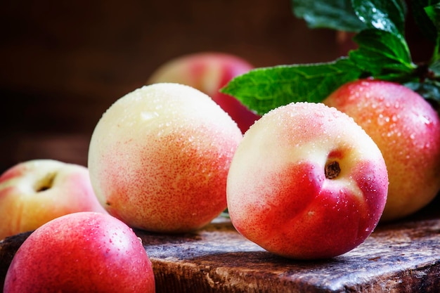 Small nectarines on the table vintage wooden background selective focus