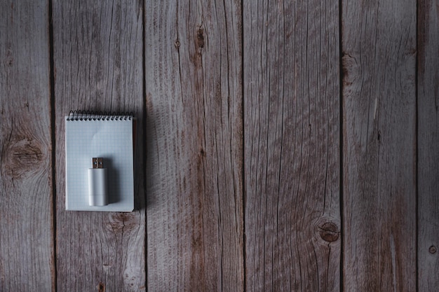 Small notebook and USB flash drive on wooden background Top view Copy space Selective focus