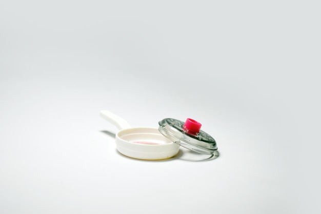 Photo a small pan with a red handle sits on a white surface child's toys