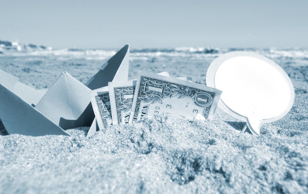 Small paper boat three one paper dollar bills and blank speech bubble