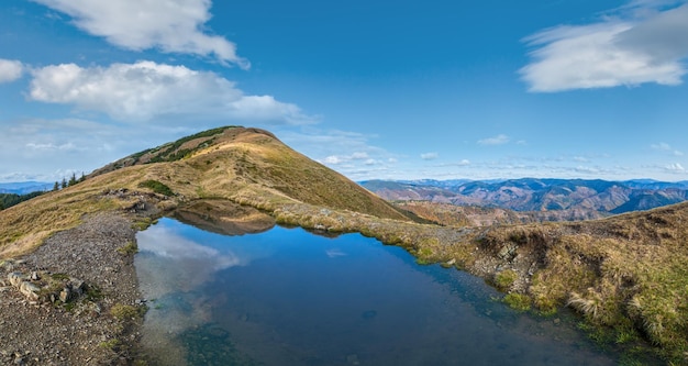 Foto piccolo lago pittoresco con riflessi di nuvole sul monte strymba bella giornata d'autunno nei monti carpazi vicino al villaggio di kolochava transcarpathia ucraina