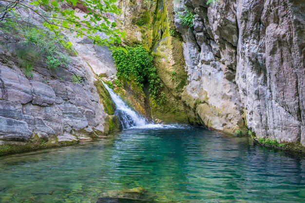 Una piccola cascata pittoresca in un'accogliente laguna di montagna