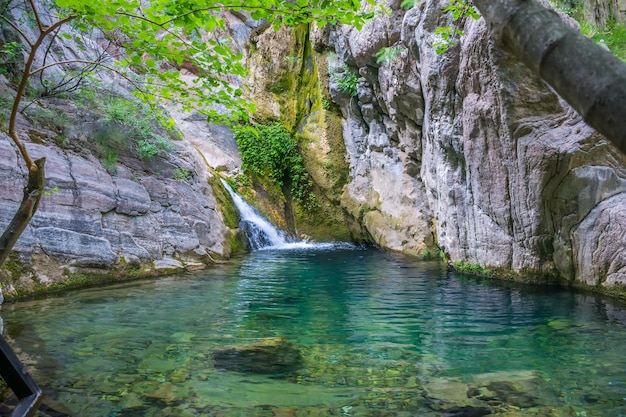 Una piccola cascata pittoresca in un'accogliente laguna di montagna