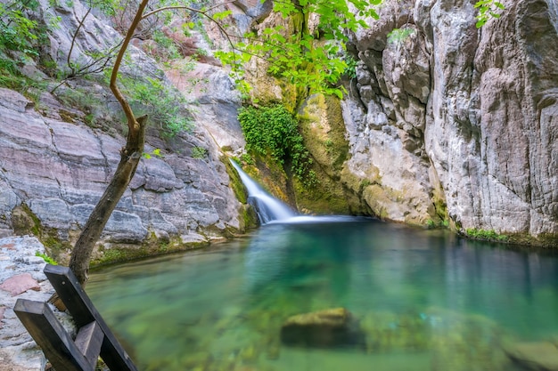 A small picturesque waterfall in a cozy mountain lagoon