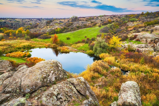 A small pile of stones in a green-yellow field against the background of sky in beautiful Ukraine