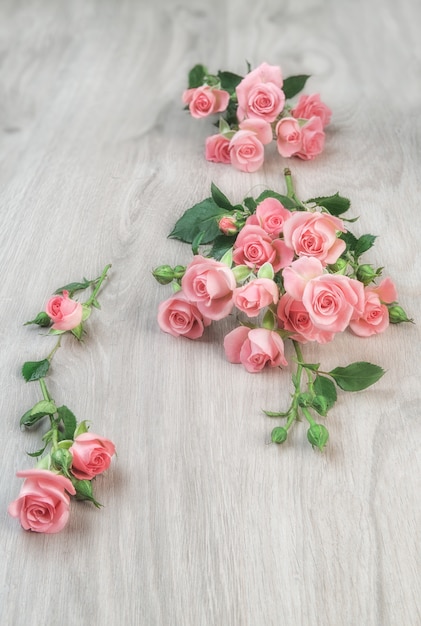 Small pink roses on wooden table, 