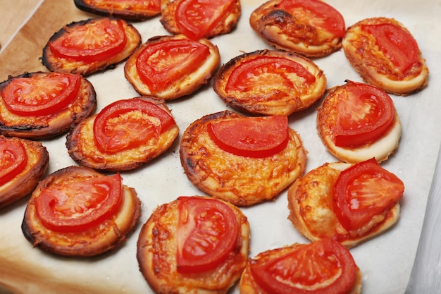 Small pizzas on baking paper close up