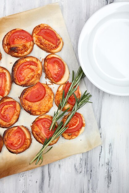 Small pizzas on baking paper close up