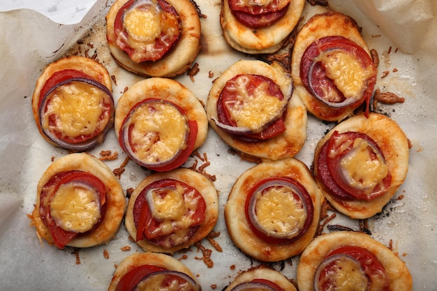 Small pizzas on baking paper close up