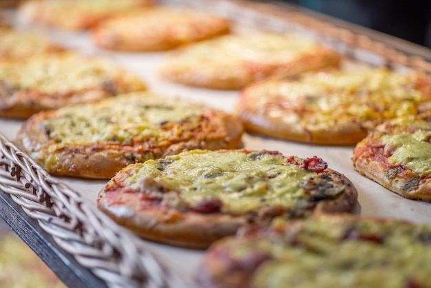 Small pizzas and pastries in the basket on the bakery window