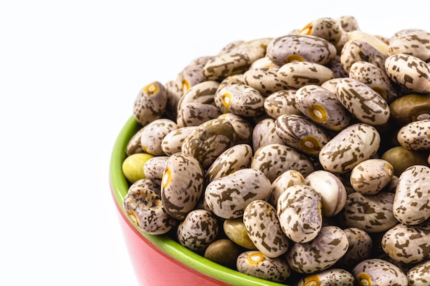 Small portion of brazilian beans on isolated white surface, pot with raw bean seeds, isolated on white surface.