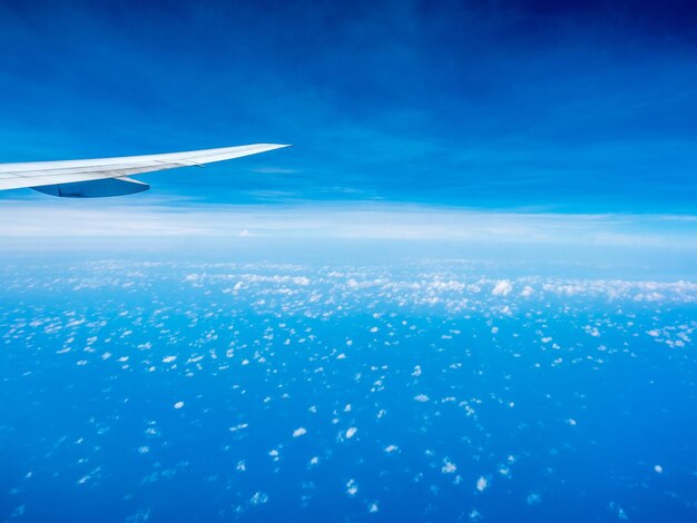 写真 航空機の窓から見た航空機の翼を持つ青い空の小さなふくらんでいる雲