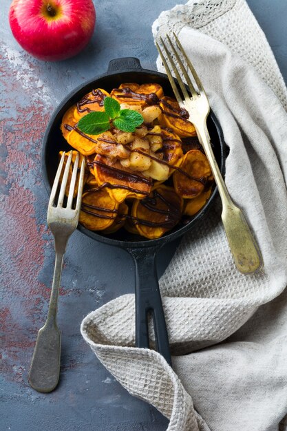 Small pumpkin pancakes with chocolate sauce in pan on the vintage