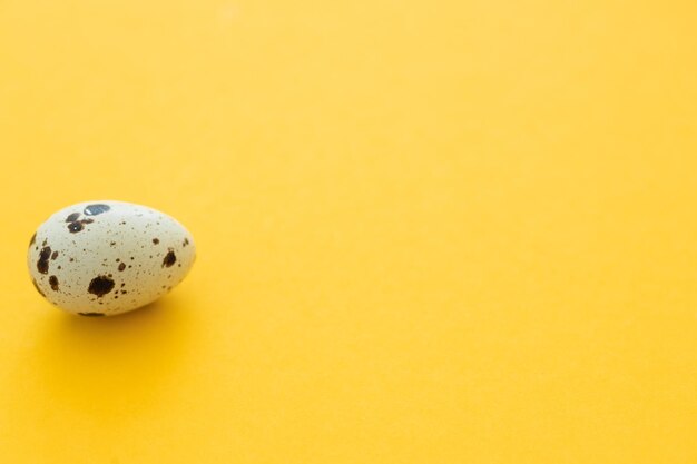 Small quail eggs on a yellow background healthy food